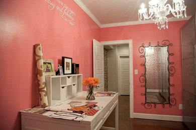Diseño de sala de manualidades de tamaño medio sin chimenea con paredes rosas, suelo de madera oscura y escritorio independiente