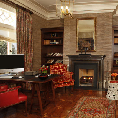 Example of a classic freestanding desk dark wood floor home office design in San Francisco with brown walls and a standard fireplace