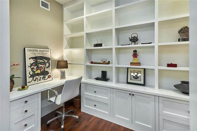 Home office - large traditional built-in desk medium tone wood floor and brown floor home office idea in San Francisco with gray walls and no fireplace