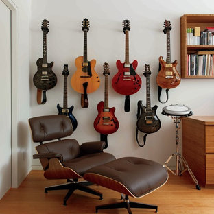Exempel på ett modernt hemmastudio, med vita väggar och mellanmörkt trägolv