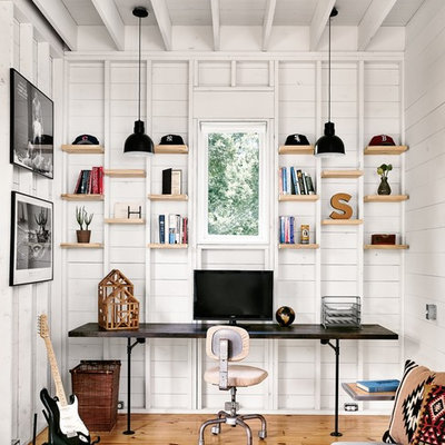 Study room - small cottage built-in desk light wood floor study room idea in Austin with white walls