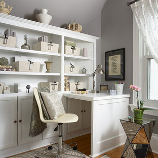 Example of a classic built-in desk medium tone wood floor home office design in Minneapolis with gray walls