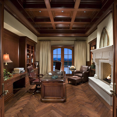 Example of a classic freestanding desk dark wood floor home office design in Los Angeles with beige walls and a standard fireplace