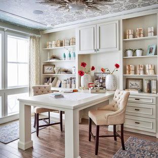 Immagine di uno studio chic con pavimento in legno massello medio e scrivania incassata