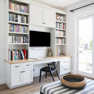 Mittelgroßes Klassisches Arbeitszimmer ohne Kamin mit weißer Wandfarbe, braunem Holzboden, Einbau-Schreibtisch und braunem Boden in Orange County