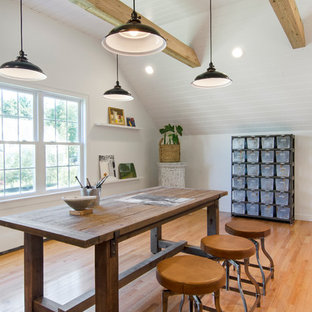Großes Country Arbeitszimmer ohne Kamin mit Studio, weißer Wandfarbe, braunem Holzboden und freistehendem Schreibtisch in Boston