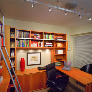 Esempio di un piccolo studio tradizionale con scrivania incassata, libreria, pareti beige, pavimento beige e nessun camino