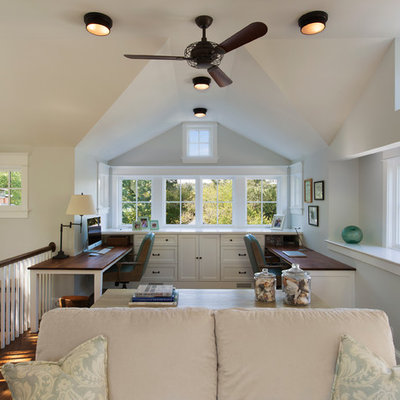 Example of a large classic built-in desk medium tone wood floor study room design in DC Metro with white walls