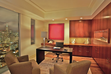 Foto di uno studio design con pareti beige, pavimento in legno massello medio e scrivania autoportante