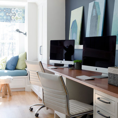 Study room - large transitional built-in desk medium tone wood floor study room idea in Boston with blue walls and no fireplace