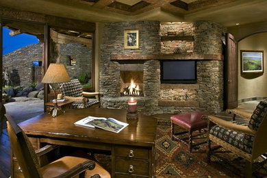 フェニックスにある広いラスティックスタイルのおしゃれな書斎 (ベージュの壁、標準型暖炉、石材の暖炉まわり、自立型机) の写真