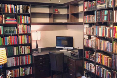 Ejemplo de despacho clásico de tamaño medio sin chimenea con biblioteca, paredes beige, suelo de madera en tonos medios, escritorio empotrado y suelo marrón