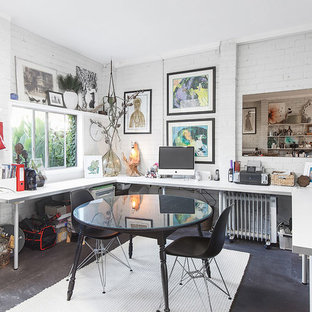 Idées déco pour un bureau éclectique de taille moyenne et de type studio avec un mur blanc, béton au sol, un bureau intégré et un sol noir.