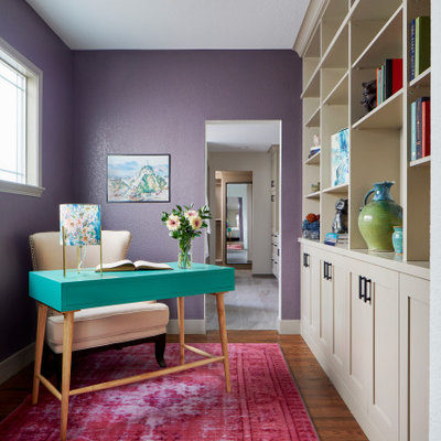 Transitional freestanding desk dark wood floor and brown floor study room photo in Denver with purple walls
