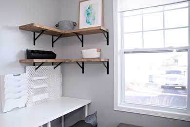 Ejemplo de despacho actual pequeño sin chimenea con paredes grises, suelo laminado, escritorio independiente y suelo marrón