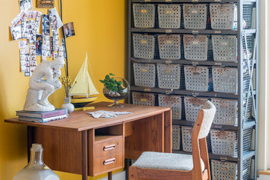 Inspiration for an eclectic freestanding desk medium tone wood floor home office remodel in New York with yellow walls