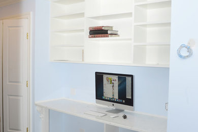 ニューヨークにある中くらいなトランジショナルスタイルのおしゃれな書斎 (青い壁、濃色無垢フローリング、暖炉なし、造り付け机) の写真