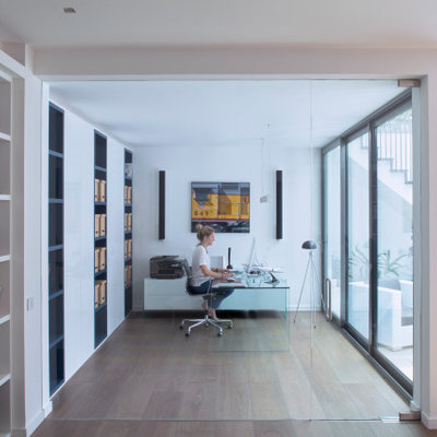 Study room - large contemporary freestanding desk medium tone wood floor and beige floor study room idea in London with white walls