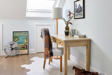 Imagen de despacho tradicional renovado con paredes azules, suelo de madera en tonos medios, escritorio independiente y suelo marrón