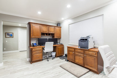 Elegant built-in desk home office photo in Denver with gray walls
