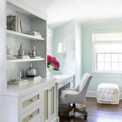 Mid-sized transitional built-in desk brown floor and medium tone wood floor study room photo in New York with green walls