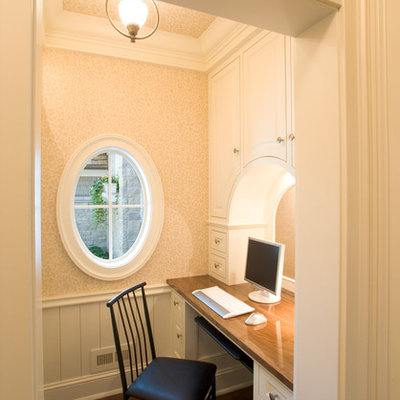 Example of a classic built-in desk dark wood floor home office design in Minneapolis with beige walls