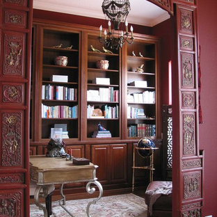 Idéer för mellanstora orientaliska arbetsrum, med ett bibliotek, röda väggar, mellanmörkt trägolv och ett fristående skrivbord