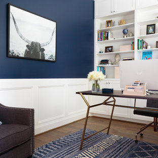 Mittelgroßes Klassisches Arbeitszimmer mit Arbeitsplatz, blauer Wandfarbe, braunem Holzboden, freistehendem Schreibtisch und braunem Boden in Houston