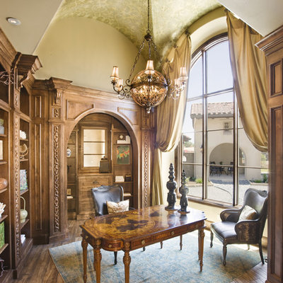 Example of a tuscan freestanding desk dark wood floor home office design in Austin with beige walls