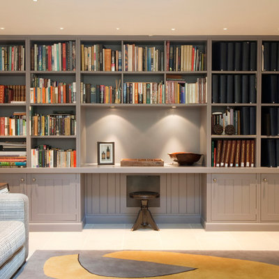 Example of a small classic built-in desk home office library design in London with white walls