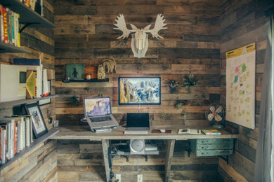 Cette image montre un bureau chalet de type studio avec un mur marron et un bureau intégré.
