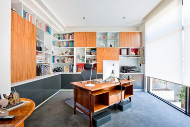 Großes Modernes Arbeitszimmer ohne Kamin mit Arbeitsplatz, weißer Wandfarbe, Teppichboden und freistehendem Schreibtisch in Melbourne