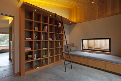Идея дизайна: большой домашняя библиотека в современном стиле с бетонным полом, серыми стенами и серым полом