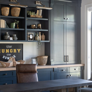 Country Arbeitszimmer mit weißer Wandfarbe, braunem Holzboden, freistehendem Schreibtisch und braunem Boden in Salt Lake City