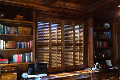 Ejemplo de despacho tradicional de tamaño medio con paredes marrones y escritorio empotrado