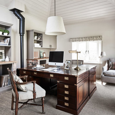 Study room - traditional freestanding desk carpeted study room idea in Wiltshire with white walls and a wood stove