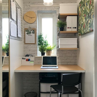 Design ideas for a contemporary study in Buckinghamshire with white walls, light hardwood flooring, a built-in desk and beige floors.