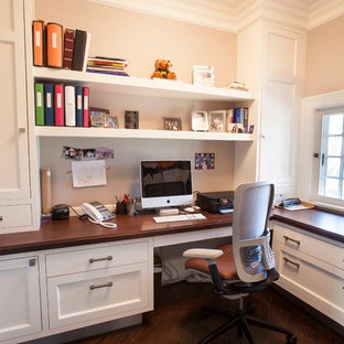 Example of a transitional built-in desk home office design in New York