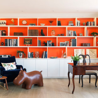 Inspiration for an eclectic home office in London with a reading nook, orange walls, a freestanding desk and beige floors.