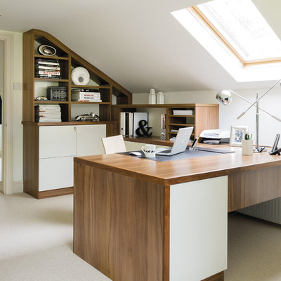 Inspiration for a mid-sized contemporary built-in desk carpeted and beige floor study room remodel in Manchester with white walls
