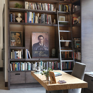 Bild på ett mellanstort funkis arbetsrum, med klinkergolv i keramik, ett fristående skrivbord, grått golv, ett bibliotek, vita väggar, en dubbelsidig öppen spis och en spiselkrans i metall