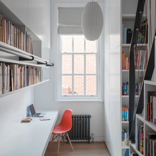 Design ideas for a contemporary home office in London with a reading nook, white walls, medium hardwood flooring, a built-in desk and brown floors.