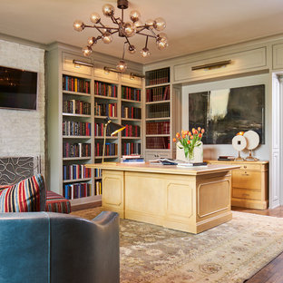 Idéer för vintage hemmabibliotek, med beige väggar, mellanmörkt trägolv, en spiselkrans i tegelsten, ett fristående skrivbord och brunt golv