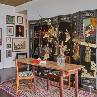 Idéer för mellanstora orientaliska hemmabibliotek, med vita väggar, betonggolv och ett fristående skrivbord