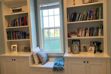 Ejemplo de despacho de estilo americano de tamaño medio con paredes azules, suelo de madera clara y suelo marrón