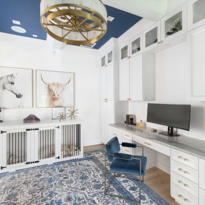 Example of a large transitional built-in desk light wood floor and coffered ceiling study room design in Austin with white walls