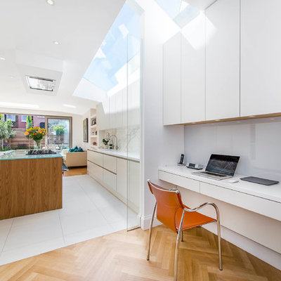 Inspiration for a small contemporary built-in desk light wood floor and beige floor study room remodel in London with white walls
