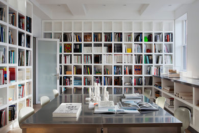 Immagine di uno studio minimalista con pareti bianche, scrivania autoportante e libreria