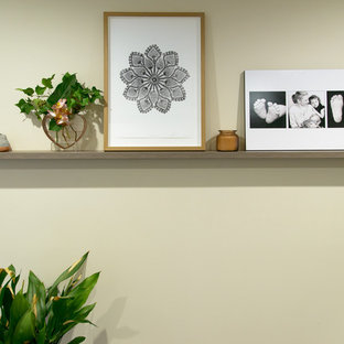 Bild på ett mellanstort funkis hemmabibliotek, med beige väggar, heltäckningsmatta och ett inbyggt skrivbord