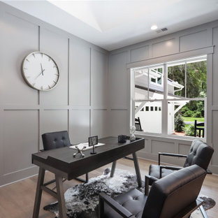 Example of a transitional freestanding desk medium tone wood floor, brown floor and wall paneling study room design in Atlanta with gray walls and no fireplace